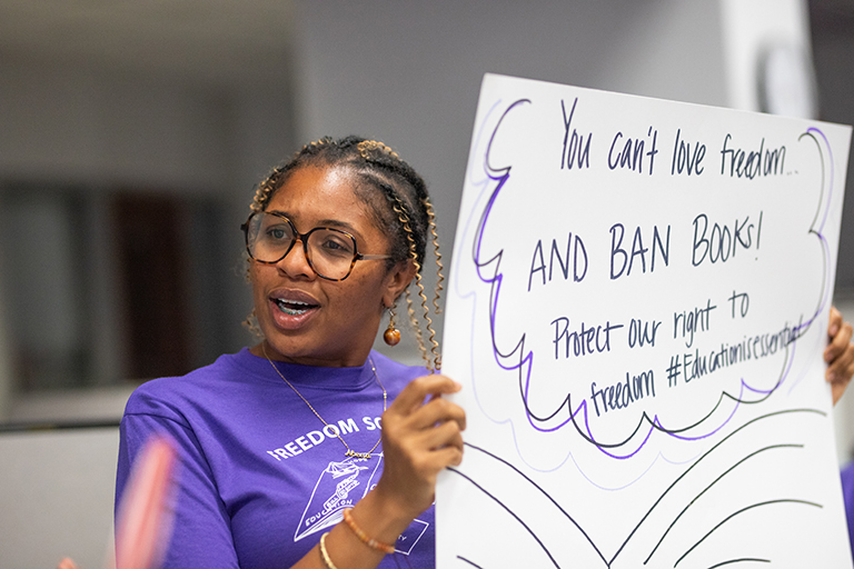 Amber Dukes, mentor, holding a sign during a presentation